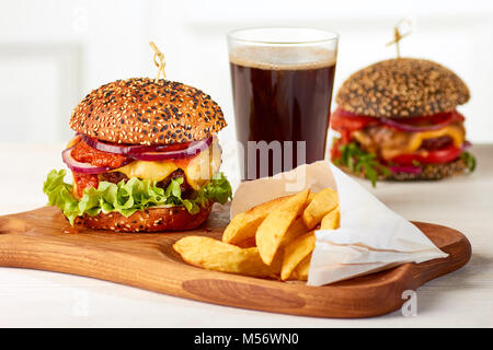 Due hamburger con patatine e un bicchiere di coca cola Foto Stock