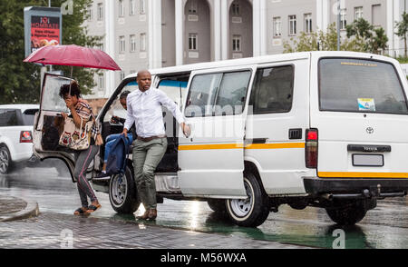 Popolo africano uscendo di taxi in centro citta'. Foto Stock