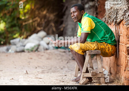 Stone Town Zanzibar - Gennaio 20, 2015: uomo seduto sulla panca di legno cercando di distanza Foto Stock