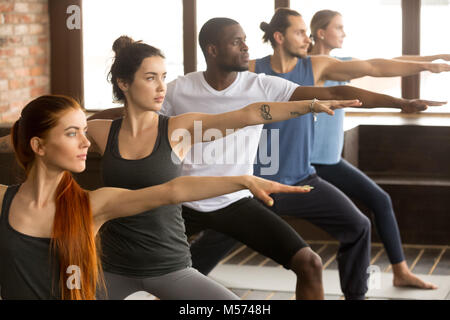 Gruppo di yogi persone nella posizione del Guerriero due Foto Stock