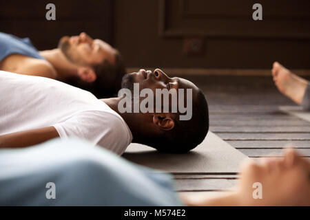 Gruppo di sportivi in Savasana esercizio Foto Stock