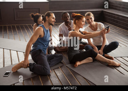 Sorridente multirazziale facendo le persone selfie sullo smartphone a yoga t Foto Stock