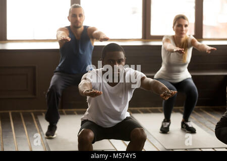 Giovani afro-americano facendo esercizi di squat al gruppo fitnes Foto Stock
