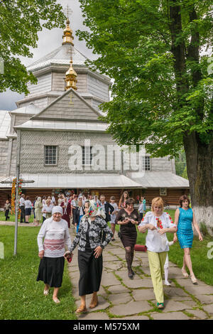 Churchgoers lasciando dopo la messa presso la Santa Trinità Chiesa Greco-cattolica, nel villaggio di Mykulychyn, vicino alla città di Yaremche, montagne dei Carpazi, Ucraina Foto Stock