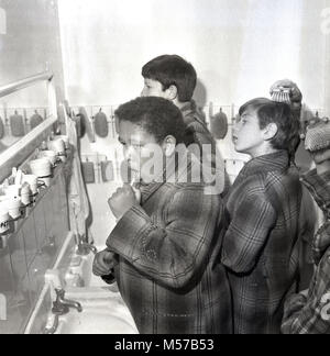 1968, storico, Londra Sud, i ragazzi a uno stato boarding school nel loro vestaglie la pulizia dei denti prima di andare a dormire. Foto Stock