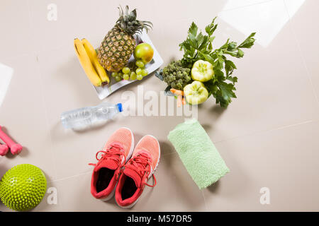 Scarpe sportive sneakers, acqua, nastro di misurazione e le mele su sfondo bianco. Vista superiore attrezzature sportive. Vita sana e cibo sano concetto Foto Stock