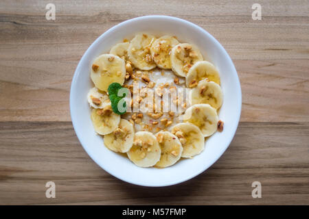 Farina di avena con banana, frutta secca e miele Foto Stock