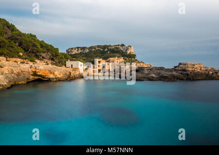 La setosa acqua del Mar Mediterraneo in una lunga esposizione fotografia di La Caló des Moro sull'isola di Mallorca, Spagna. Foto Stock