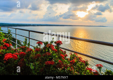 Bellissima alba al mattino che raggi di sole rompere attraverso il colorato cloud e riflettono la luce gialla di sole oltre il giardino sul balcone Foto Stock