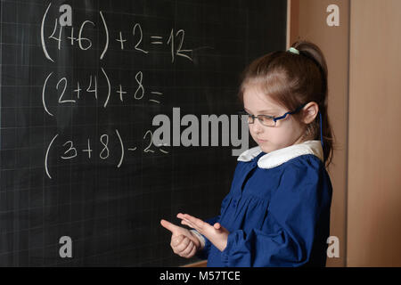 Italiano Scuola elementare ragazza prima-grader risolvere la matematica Foto Stock