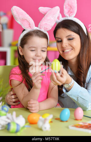 La ragazza con la madre dipingere le uova Foto Stock