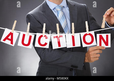 Vista dettagliata sezione mediana di imprenditore pinning asta carte su stendibiancheria Foto Stock