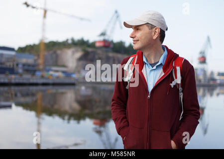 Turistico con zaino in piedi sul lungomare di Turku, Finlandia Foto Stock