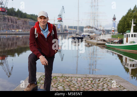 Turistico con zaino in piedi sul lungomare di Turku, Finlandia Foto Stock