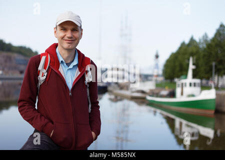 Turistico con zaino in piedi sul lungomare di Turku, Finlandia Foto Stock