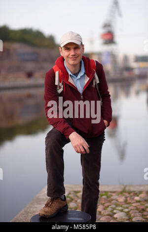 Turistico con zaino in piedi sul lungomare di Turku, Finlandia Foto Stock