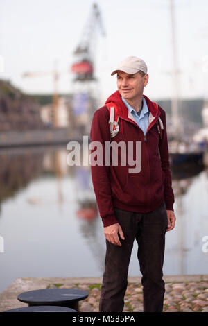 Turistico con zaino in piedi sul lungomare di Turku, Finlandia Foto Stock