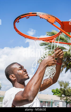 Miami Florida,Liberty City,African Square Park,centro città,basso reddito,povertà,maschio nero,teen teen teenager studenti studenti basket hoop Foto Stock