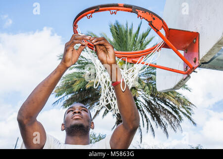 Miami Florida,Liberty City,African Square Park,centro città,basso reddito,povertà,maschio nero,teen teen teenager studenti studenti basket hoop Foto Stock