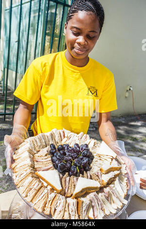 Miami Florida,Liberty City,African Square Park,centro città,basso reddito,povertà,donne nere,sandwich piatto,cibo,uva,FL080216033 Foto Stock