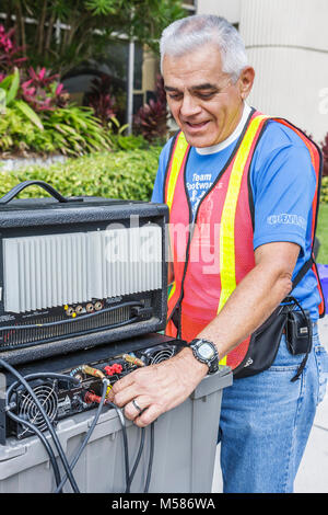 Miami Florida,Brickell District,Carnaval 8K Run,preparazione,evento della comunità,elettricista,ingegnere del suono,Immigran etnico latino ispanico latino-latino Foto Stock