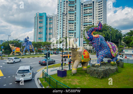 SINGAPORE, Singapore - 01 febbraio 2018: Outdoor View non identificato di persone che camminano per le strade con alcune vetture ed enormi lapidato elefanti colorati si trova in Little India di Singapore Foto Stock