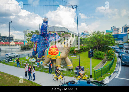 SINGAPORE, Singapore - 01 febbraio 2018: Outdoor View non identificato di persone che camminano per le strade con alcune vetture ed enormi lapidato elefanti colorati si trova in Little India di Singapore Foto Stock