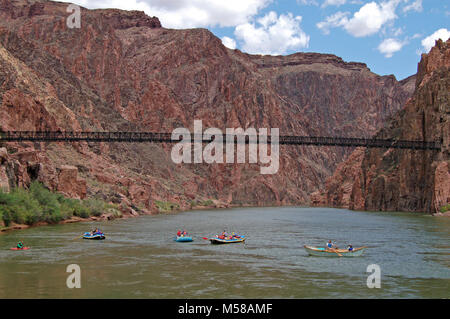 Parco Nazionale del Grand Canyon Nero barche ponte . I barcaioli lasciando il Phantom Ranch spiaggia in barca con il ponte nero dietro e che attraversano il fiume Colorado. Il South Kaibab Trail attraversa il fiume Colorado su questo stretto ponte pedonale 440 piedi/134 m attraverso e 70 piedi/21 m sopra l'acqua. Accesso a Bright Angel e Phantom Ranch è attraverso questo ponte, costruito nel 1928. Server dei criteri di rete Foto Stock