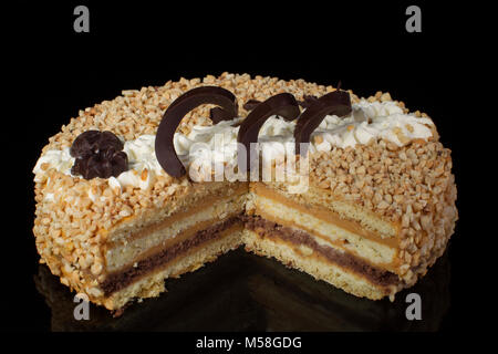 Un pezzo di torta shortcake coperti con arachidi su sfondo scuro Foto Stock