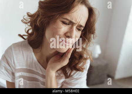 Frustrati donna alle prese con il mal di denti Foto Stock