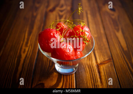 Ripe rosso pomodori marinati in una ciotola di vetro Foto Stock