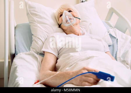Una forte donna anziana che subisce il trattamento in ospedale Foto Stock