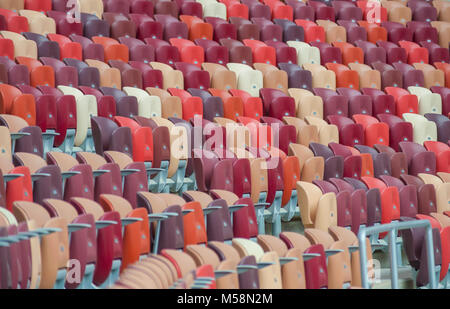 Multi-colore di poltrone in uno stadio sportivo Foto Stock