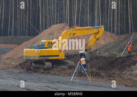 La ricostruzione della strada di campagna - escavatore giallo sul lavoro Foto Stock