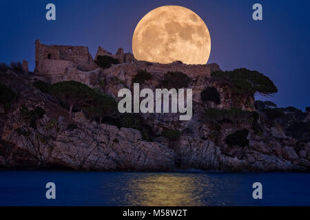 Luna piena al di sopra del vecchio castello in Costa Brava in un villaggio vacanze Fosca , Spagna Foto Stock