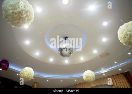 Il bianco alto soffitto con travi a vista. Decorate con sfere da discoteca.Con la retroilluminazione. Vita di notte Foto Stock