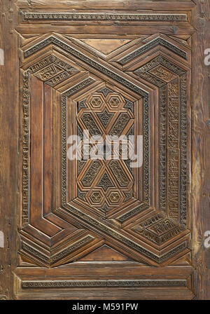 Geometrici e floreali motivi incisi di stile Mamluk ornati in legno battente di porta di madrasa di Sultan Nagm al Din Ayyub al Cairo, Egitto Foto Stock