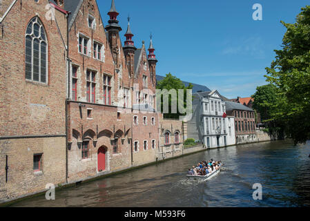 Vista di Steenhouwersdijk con una imbarcazione turistica sul canale Groenerei. Bruges, Belgio. Foto Stock