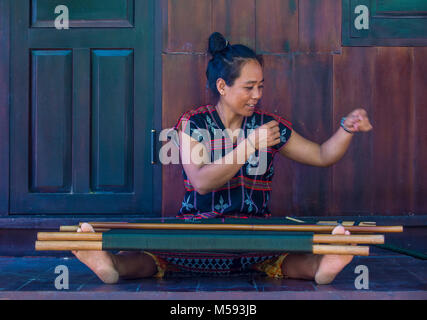 Una donna dalla minoranza Cotu si intreccia con una fascetta telaio in Quang Nam Vietnam Foto Stock