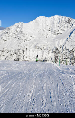 Messa a fuoco selettiva del pendio nevoso nella famosa e scenic stazione sciistica di La Thuile, Valle d'Aosta, Italia. Uno snowboarder non identificabili Foto Stock