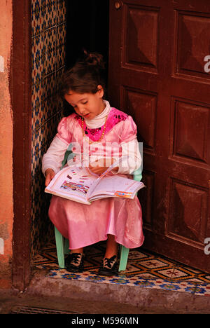 Bambina è studiare all'ingresso della casa - Marocco Foto Stock