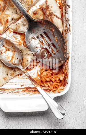 Piatto di avanzi di cuocere la pasta di formaggio e aglio pane con cucchiai su un grigio sfondo rustico Foto Stock