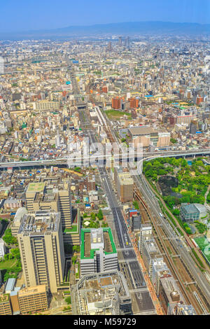 Vista aerea al di sopra dello skyline di Osaka dal ponte di osservazione della piattaforma di visualizzazione di un top di Osaka di Abeno Harukas, Giappone. Autostrade e stazioni ferroviarie sullo sfondo. Colpo verticale. Foto Stock