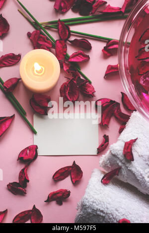 Fiori decorativi, potpourri, asciugamani e candela su sfondo rosa; con spazio per il testo; Spa concept Foto Stock