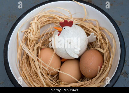 Bianco ornamento di pollo in un blu ciotola a scacchi di uova Foto Stock