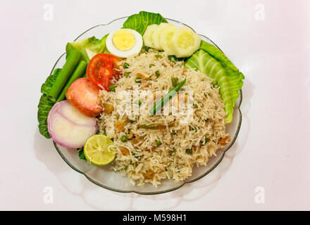 Il cibo indiano pasto di fritto pulao riso con spicchi di uova e verdura verde Foto Stock
