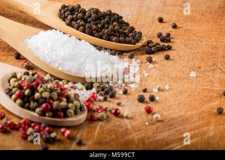 Cucchiai di sale e di pepe - Focus su grani di pepe nero Foto Stock