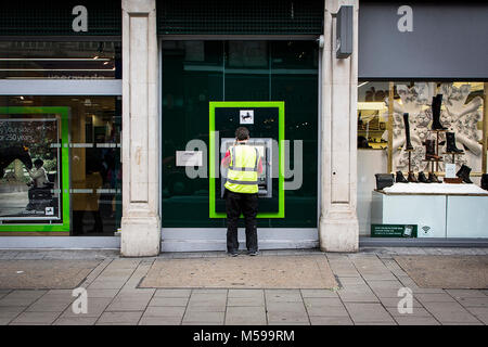 L'uomo prelevare denaro dal bancomat Foto Stock