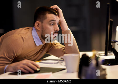 Stanco uomo sul tavolo durante la notte office Foto Stock