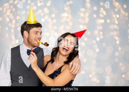 Coppia felice con party soffianti divertendosi Foto Stock